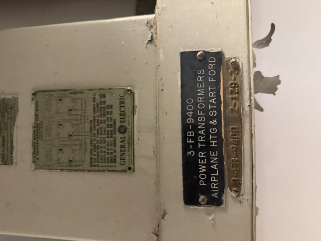 Close-up of a General Electric power-transformer cabinet aboard USS Alabama, showing the GE wiring-diagram plate and equipment plates reading '3-FB-9400 POWER TRANSFORMERS AIRPLANE HTG & START FORD.'