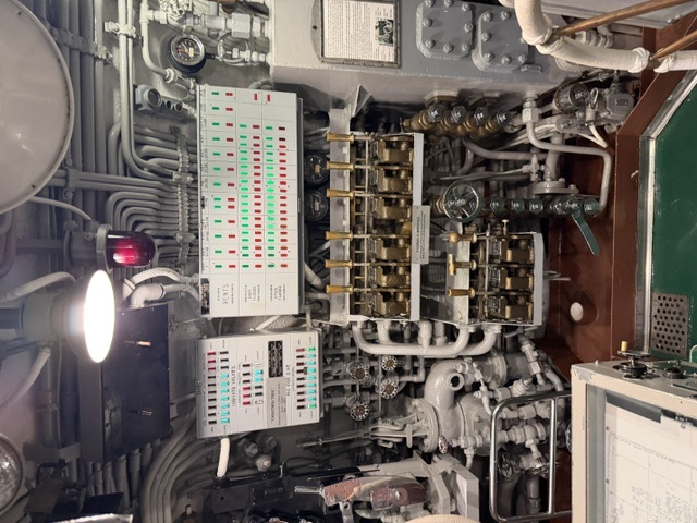 The control room ballast-control station aboard USS Drum, showing the red-and-green 'Christmas Tree' hull-opening indicator panel above brass vent-operating levers and air manifolds labeled 'VENTS' and 'INBOARD VALVES.'