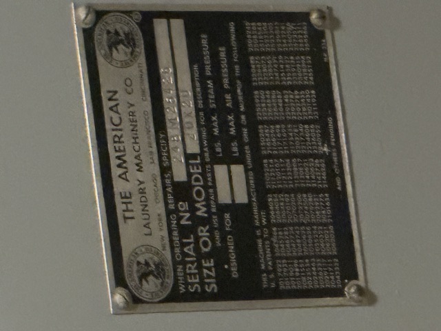 The American Laundry Machinery Co. builder's nameplate documented aboard USS Drum (SS-228) — Close-up of a metal builder's plate reading "THE AMERICAN LAUNDRY MACHINERY CO" (New York, Chicago, San Francisco, Cincinnati), Serial No 24BM25428, Size or Model 20X20, with fields for max steam and air pressure and a list of U.S. patents.