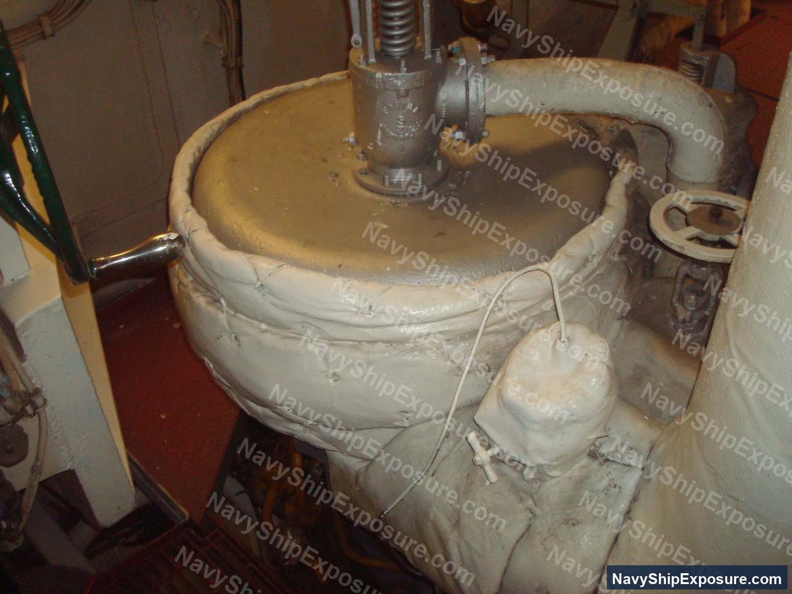 Engine room or machinery space equipment from USS Midway showing a large cylindrical vessel with insulation wrapping and connected piping systems typical of naval steam propulsion systems.
