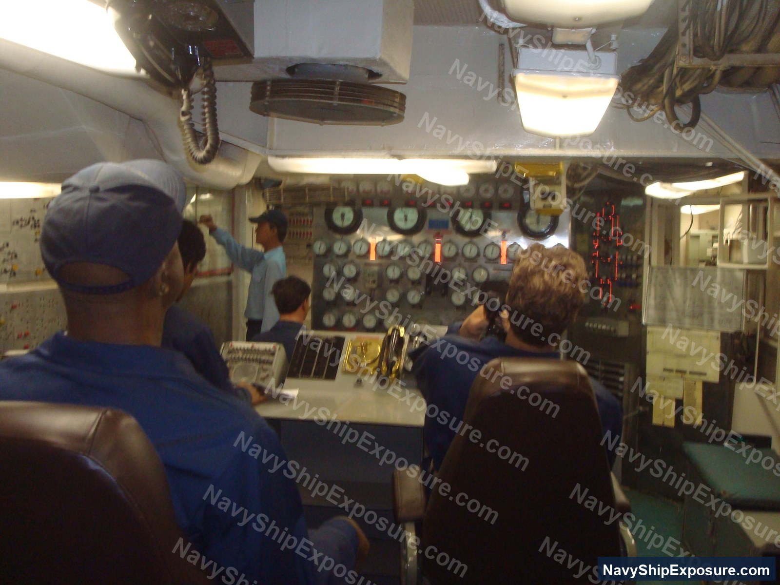 Interior view of USS Midway engine room showing control panels, gauges, monitoring equipment, and naval personnel operating machinery spaces typical of 1940s-era aircraft carrier propulsion systems.