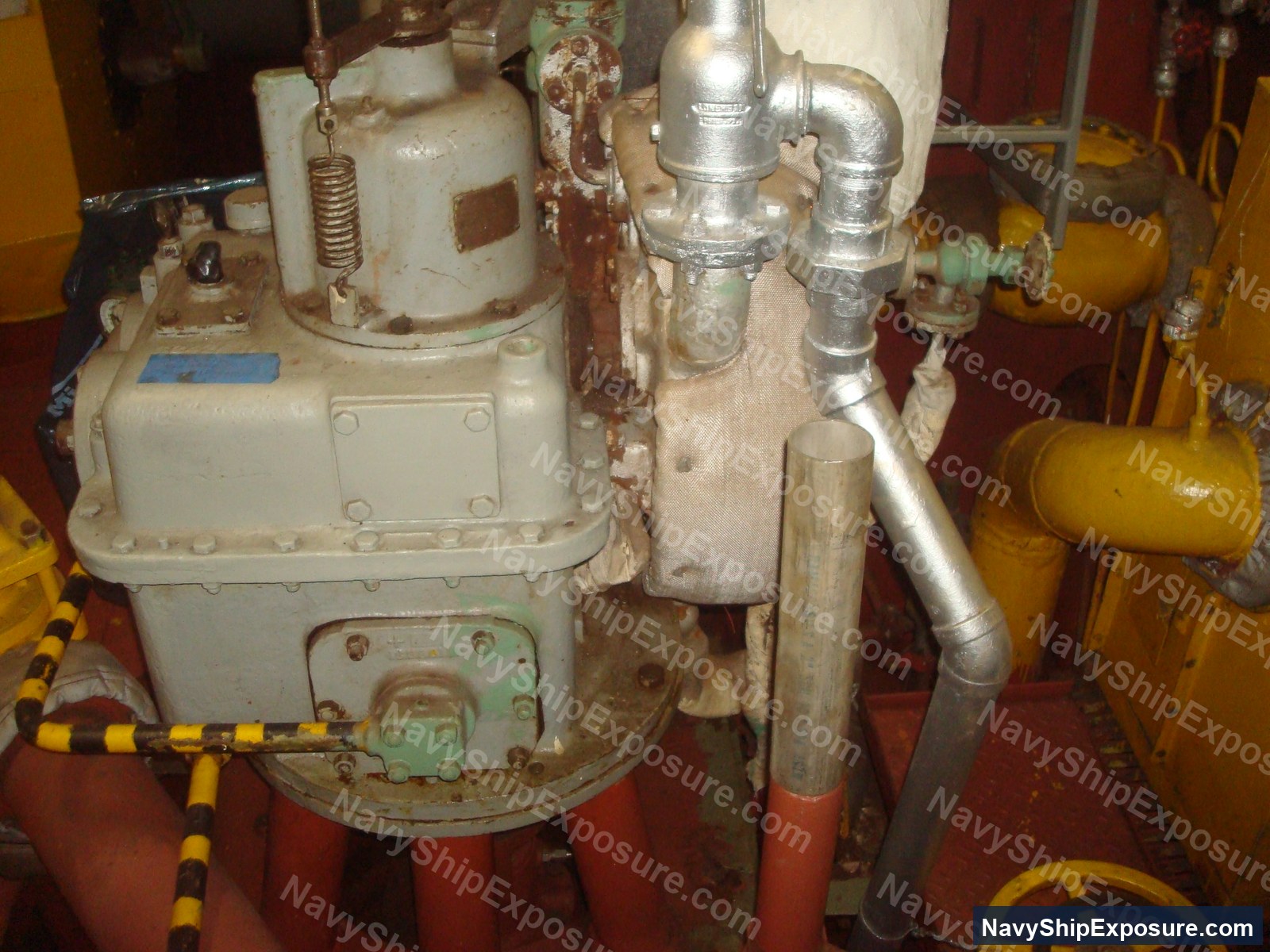 Engine room or machinery space equipment from USS Midway showing vintage industrial pumps, piping systems, and mechanical components typical of 1940s-era naval vessel propulsion systems.