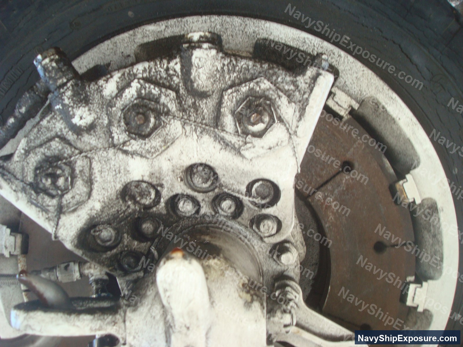 Close-up photograph of ship machinery or engine components showing gears, bolts, and metal fittings characteristic of naval propulsion or auxiliary equipment from the USS Midway era.
