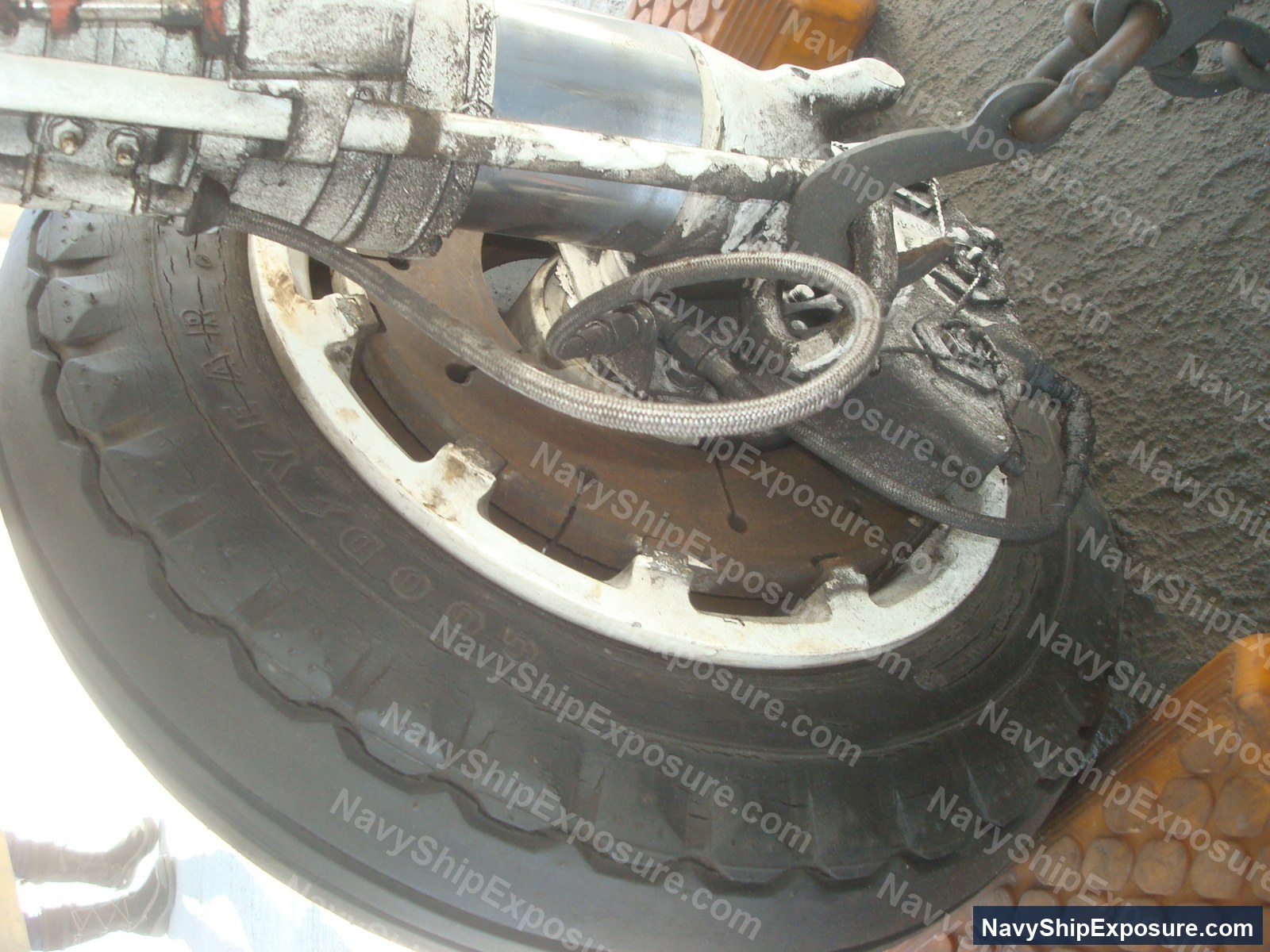 Close-up photograph of a ship's brake assembly or brake drum component with insulation wrapping and mechanical linkages, typical of machinery space equipment from the USS Midway era.