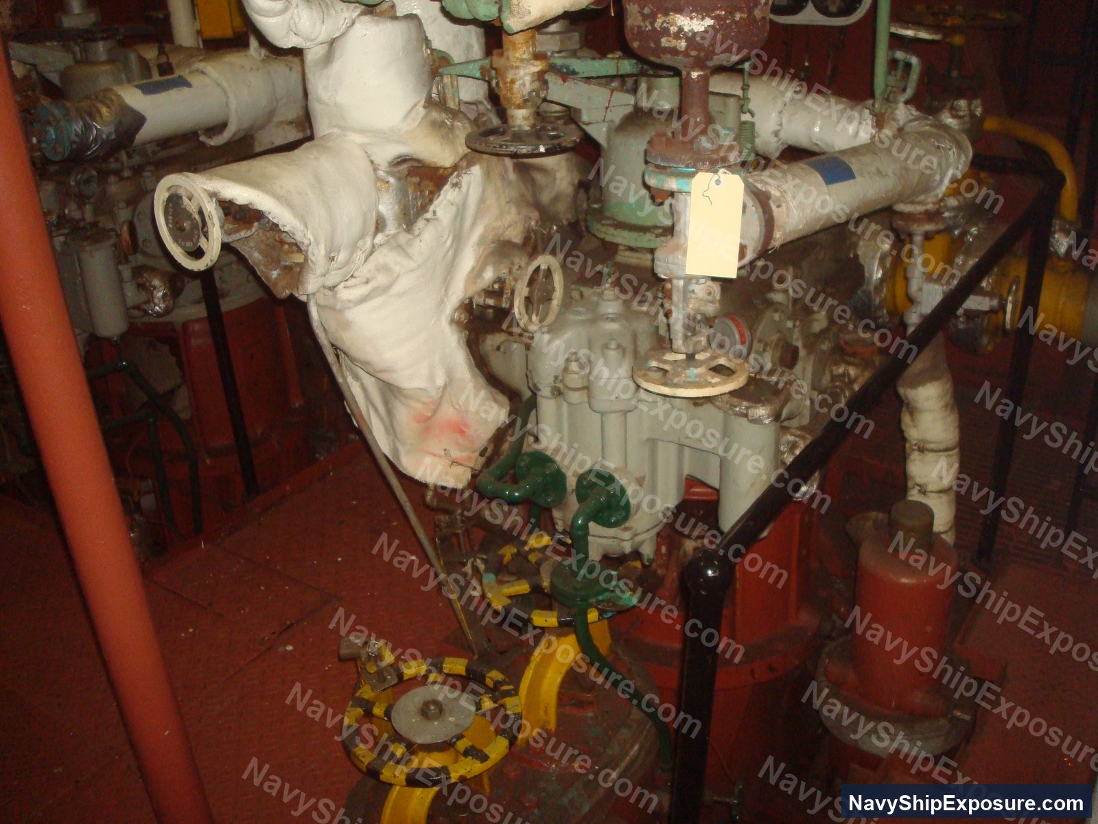 Engine room machinery space aboard USS Midway showing wrapped piping, valves, and industrial equipment typical of 1940s-era naval propulsion systems.