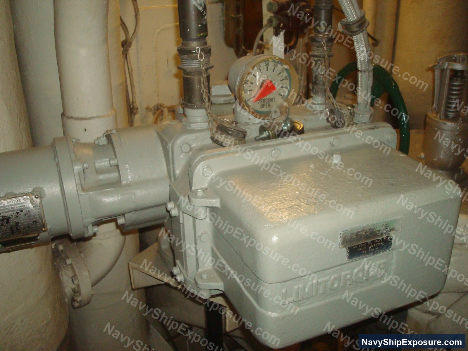 Engine room or machinery space equipment showing a Limitorgue pressure gauge, pump, piping, and various industrial valves typical of USS Midway's propulsion system.
