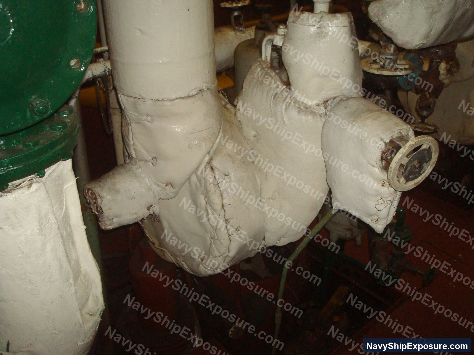 Insulated piping in an engine room or machinery space of USS Midway (CV-41), showing white thermal insulation wrapping typical of naval propulsion systems from the 1945-1992 era.